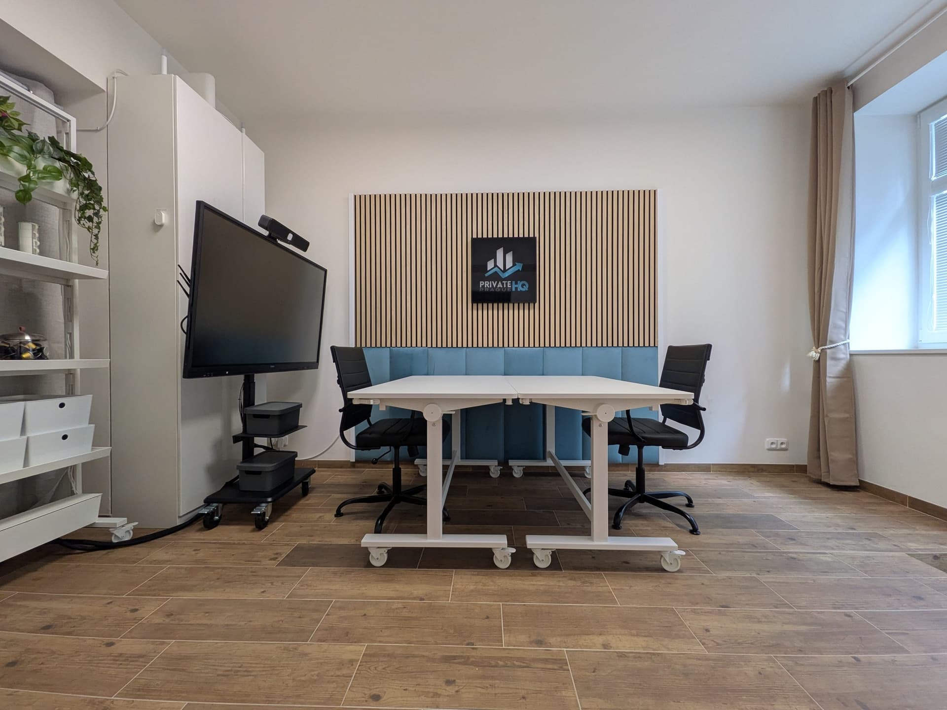 Besprechungsraum von Private HQ Prague: Lamellenwand mit hinterleuchtetem Display, Konferenzbildschirm und Besprechungstisch